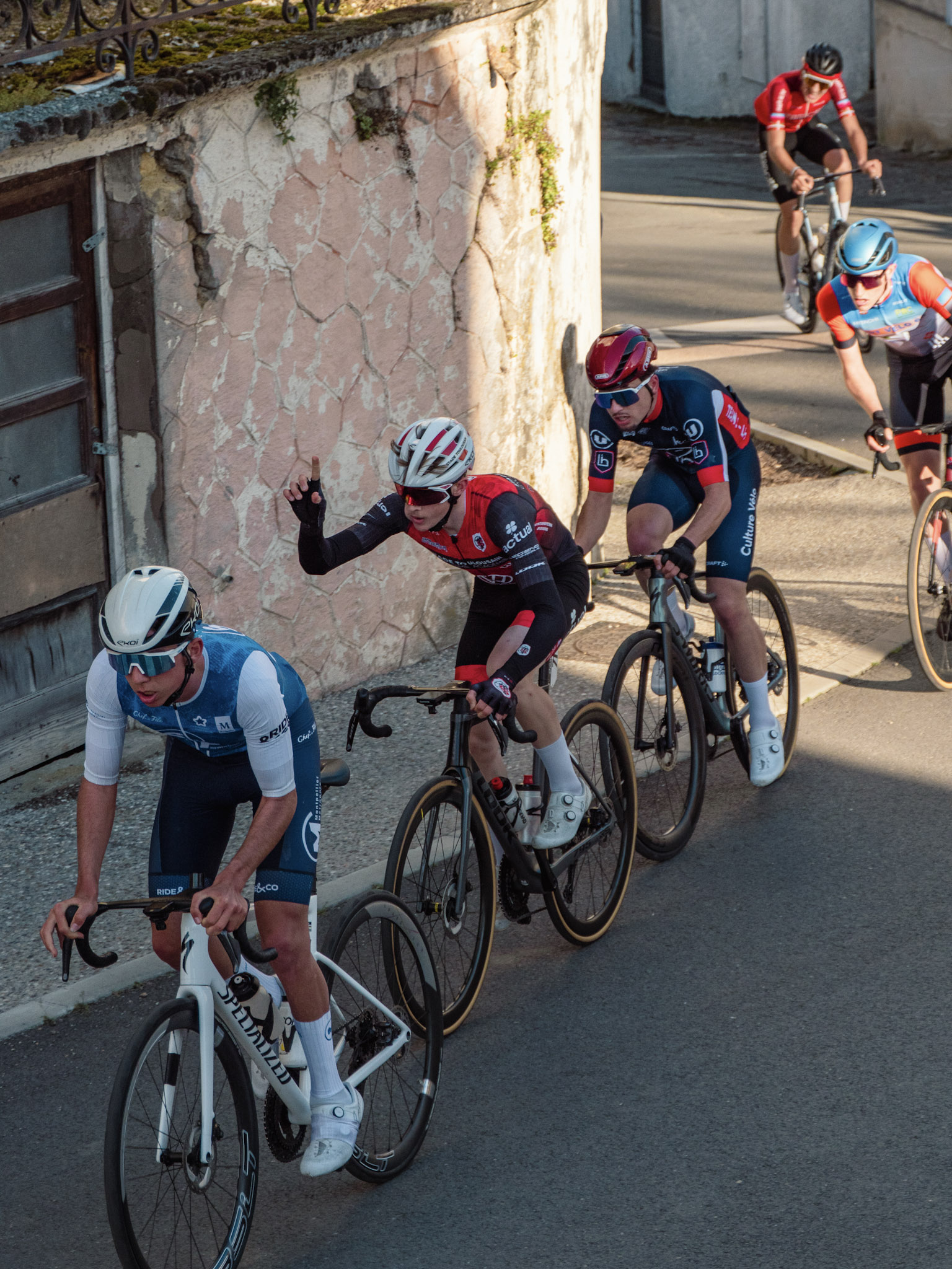 Coureurs en action dans une montée, peloton du Stade Toulousain Cyclisme